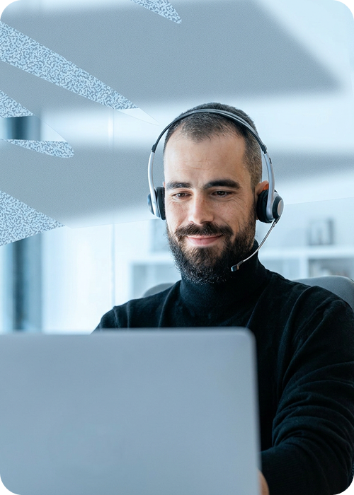 homem alegre utilizando headphone e laptop em um ambiente clean.